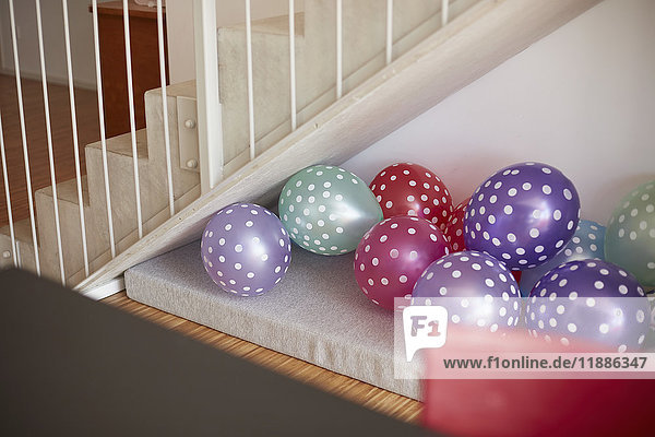 Mehrfarbige Luftballons an der Wand durch Treppenhaus zu Hause