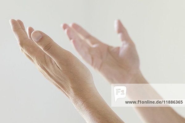 Cropped image of man gesturing hands against white background
