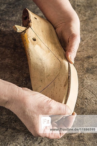 Schuhmacher  Hände halten ein Stück Leder an einem Schuhleisten  Kainisch  Steiermark  Österreich  Europa