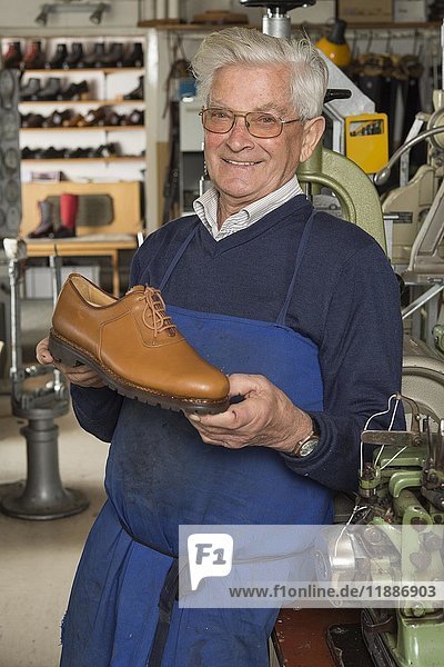 Schuhmacher  Mann mit fertigem Schuh in der Hand  in der hinteren Werkstatt  Kainisch  Steiermark  Österreich  Europa