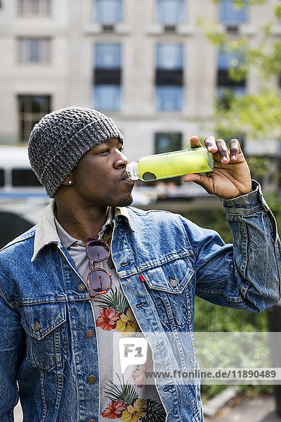 Portrait of stylish man drinking from bottle