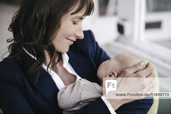 Businesswoman in cafe holding sleeping baby