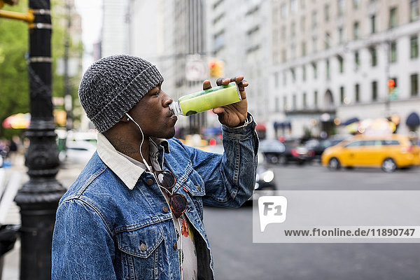 USA  New York City  Manhattan  man drinking from bottle on the street