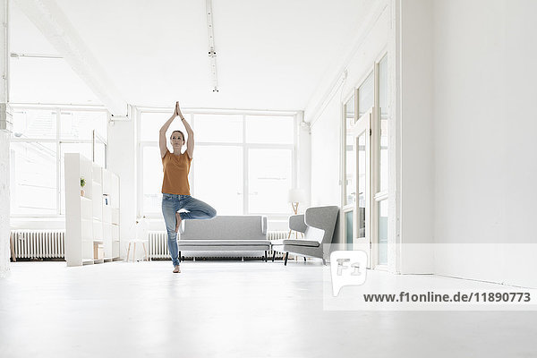Woman practising yoga in a loft