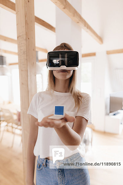 Junge Frau mit VR-Brille  Urlaubsplanung  Spielzeugstuhl in der Hand