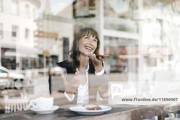 Geschäftsfrau sitzend im Cafe  mit Smartphone