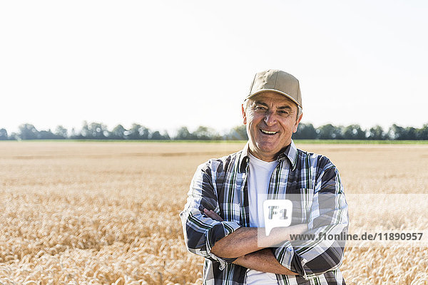 Porträt eines lachenden Seniorenbauern vor einem Feld