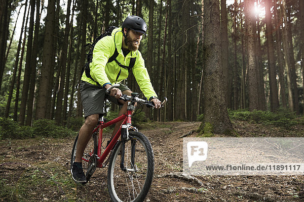 Man mountain biking in forest