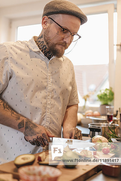 Tattooed man preparing food in the kitchen