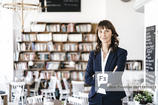 Businesswoman in cafe with arms crossed. looking at camera