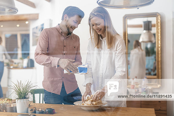 Young couple preparing dough together at home