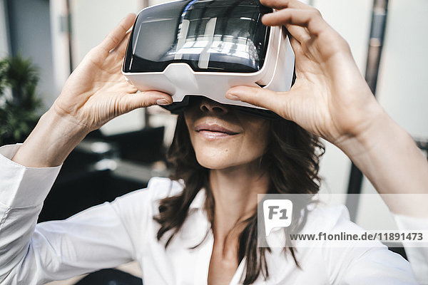 Businesswoman using VR goggles in office