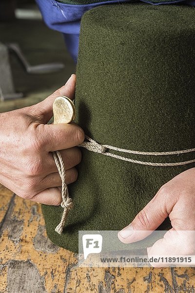 Anziehen der Formschnur um einen Wollfilzhut mit Hilfe eines Bügeleisens  Hutmacherwerkstatt  Bad Aussee  Steiermark  Österreich  Europa