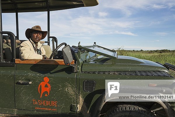 A driver and guide in a safari jeep  Kalahari Desert  Kgalagadi Transfrontier Park  Botswana  Africa