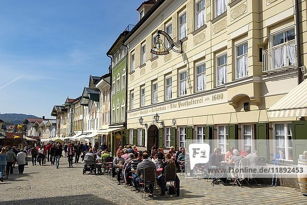 People sitting in tavern in front of row of historic houses  Marktstraße  Bad Tolz  Upper Bavaria  Bavaria  Germany  Europe
