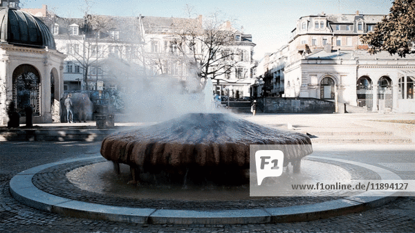 Dampf aus sprudelndem Heißwasser im Parkbrunnen