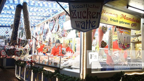 Verkäuferin verkauft Süßigkeiten auf dem nächtlichen Weihnachtsmarkt  Wiesbaden  Deutschland