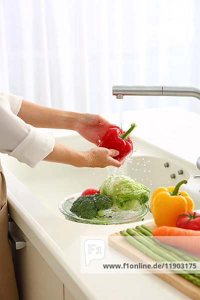 Japanese woman washing vegetables in the kitchen