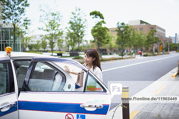 Junge japanische Frau in einem Taxi in der Innenstadt von Tokio  Japan