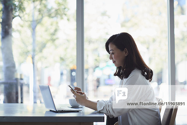 Japanese woman with laptop in a stylish cafe