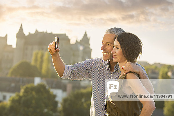 Caucasian couple posing for cell phone selfie