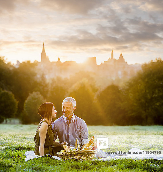Caucasian couple enjoying a picnic in grass