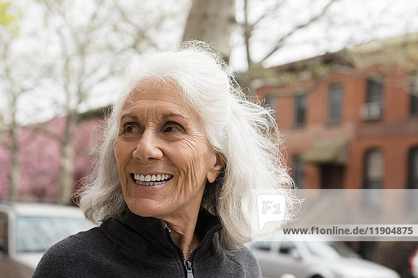 Lächelnde ältere Frau im Freien in der Stadt