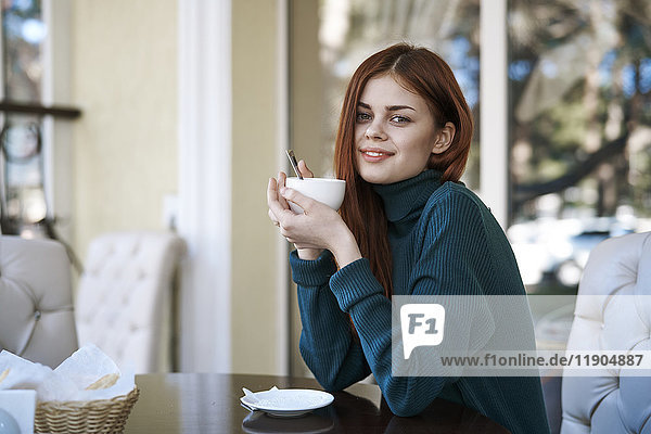 Caucasian woman drinking coffee at restaurant