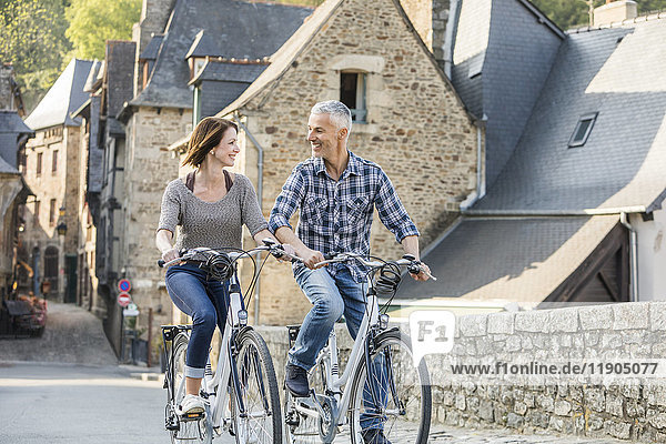 Caucasian couple riding bicycles in city