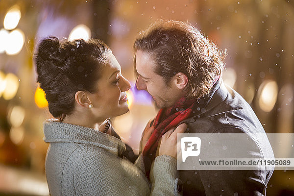 Caucasian couple hugging outdoors at night