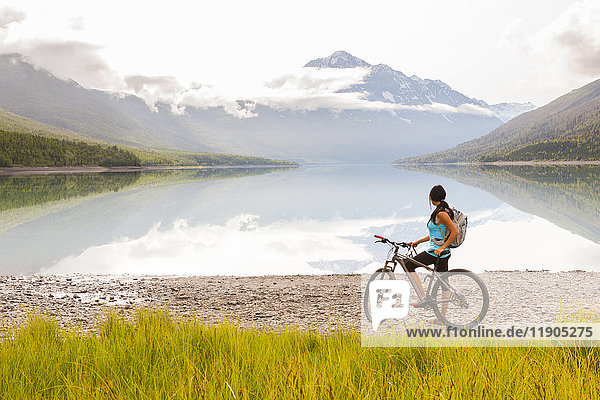 Mixed Race woman riding a bicycle near lake