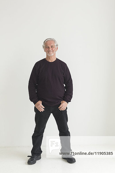 Older Caucasian man with thumbs in pockets