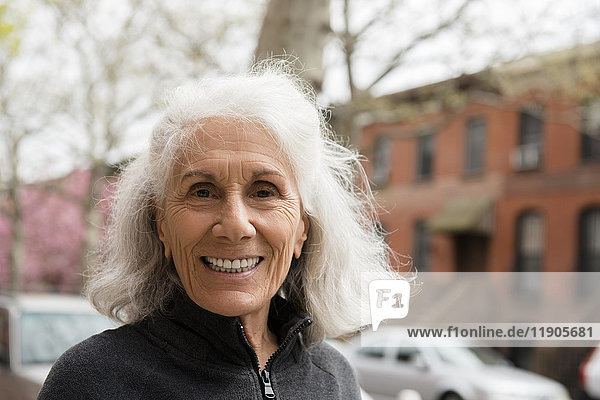 Lächelnde ältere Frau im Freien in der Stadt
