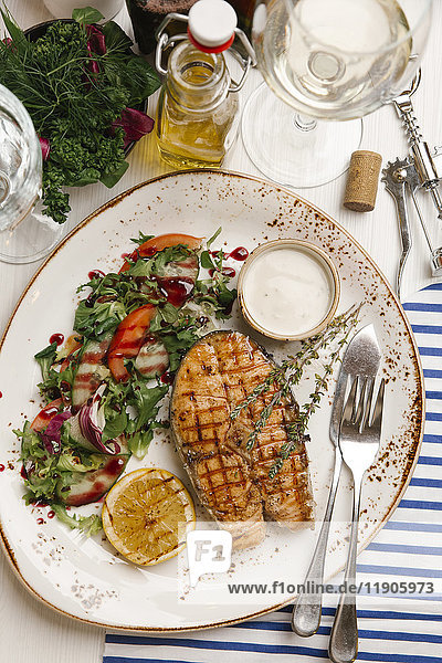 Gegrillter Fisch und Salat auf Teller mit Sauce