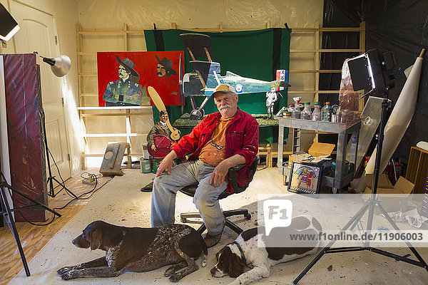 Porträt eines älteren kaukasischen Mannes in einer Werkstatt mit Hunden