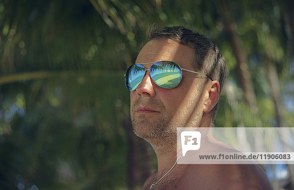Serious man wearing sunglasses in summer