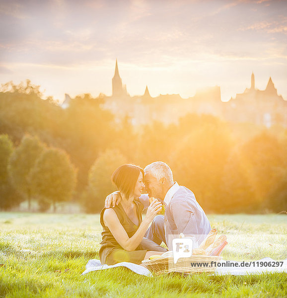 Caucasian couple enjoying picnic in grass