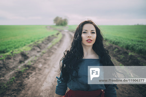 Kaukasische Frau steht auf einem Feldweg