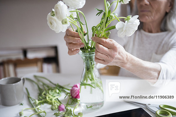 Ältere Frau arrangiert Blumen