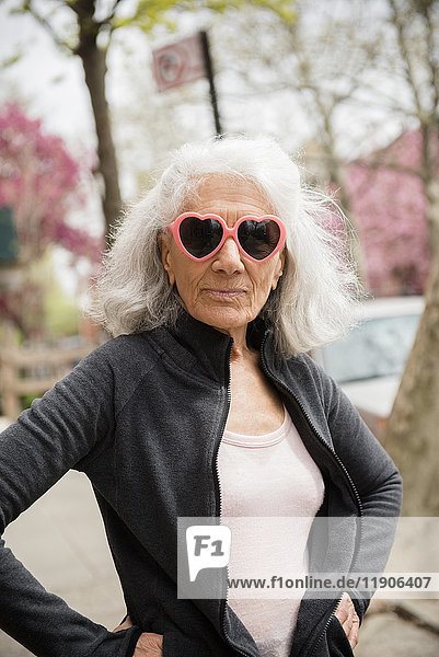Ältere Frau mit herzförmiger Sonnenbrille