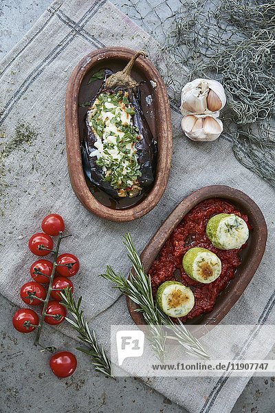 Two baked vegetable dishes in rustic serving trays (top view)