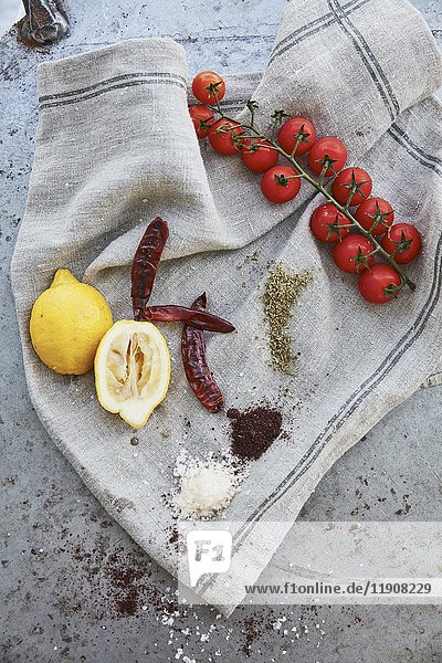 Lemons  tomatoes  chillies  and spices on a linen cloth