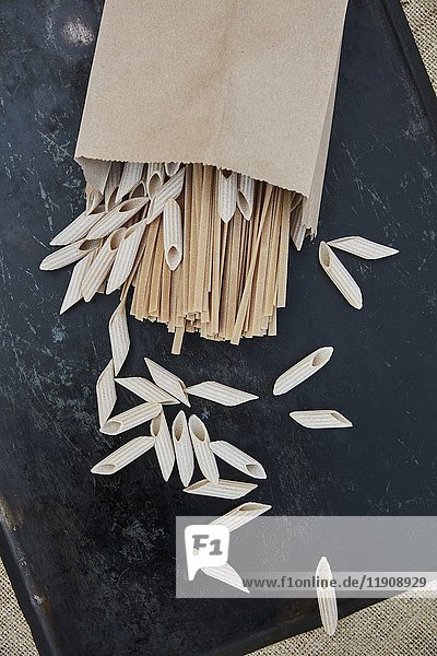 Various types of wholemeal pasta in a paper bag