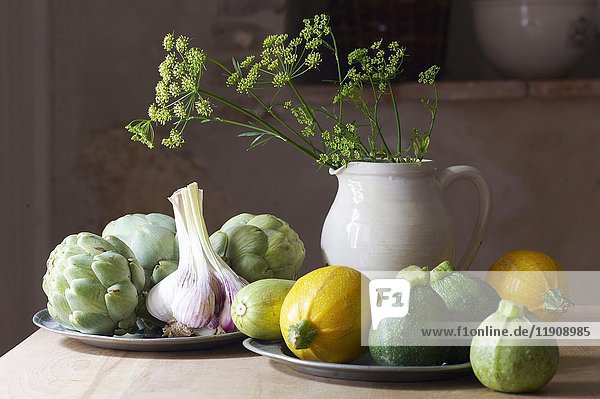 A still life with round courgettes  garlic and artichokes