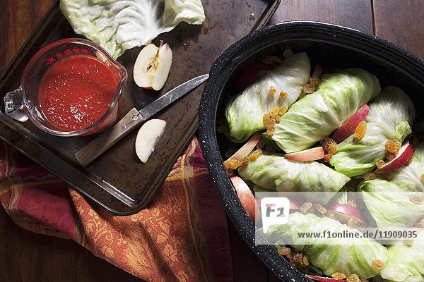 Stuffed cabbage in roasting pan with apple slices  rasins and tomato sauce