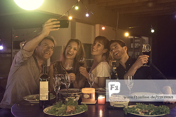 Freunde posieren für Gruppen-Selfie auf der Dinnerparty