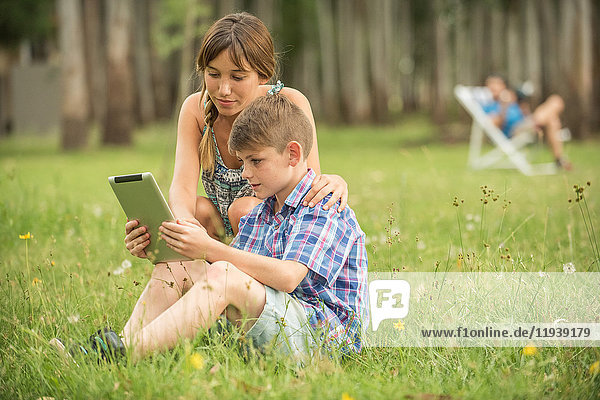 Mutter und Sohn betrachten gemeinsam das digitale Tablett im Freien