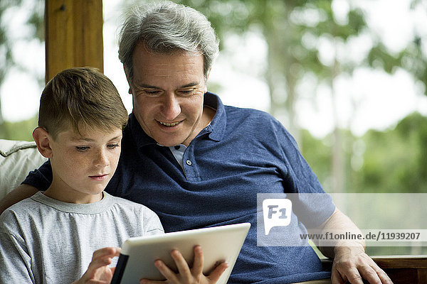 Mann mit Kind mit digitalem Tablett