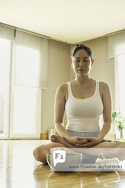 Frau auf dem Boden sitzend meditierend