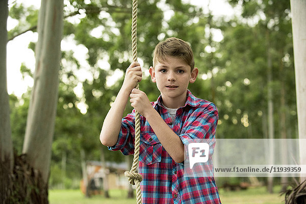 Junge auf Seilschaukel  Portrait